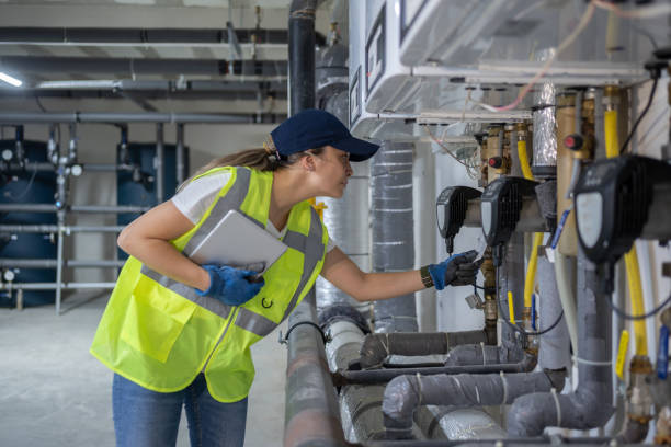 Technician Checking Heating System In The Boiler Room With Tablet In Hand HVAC services